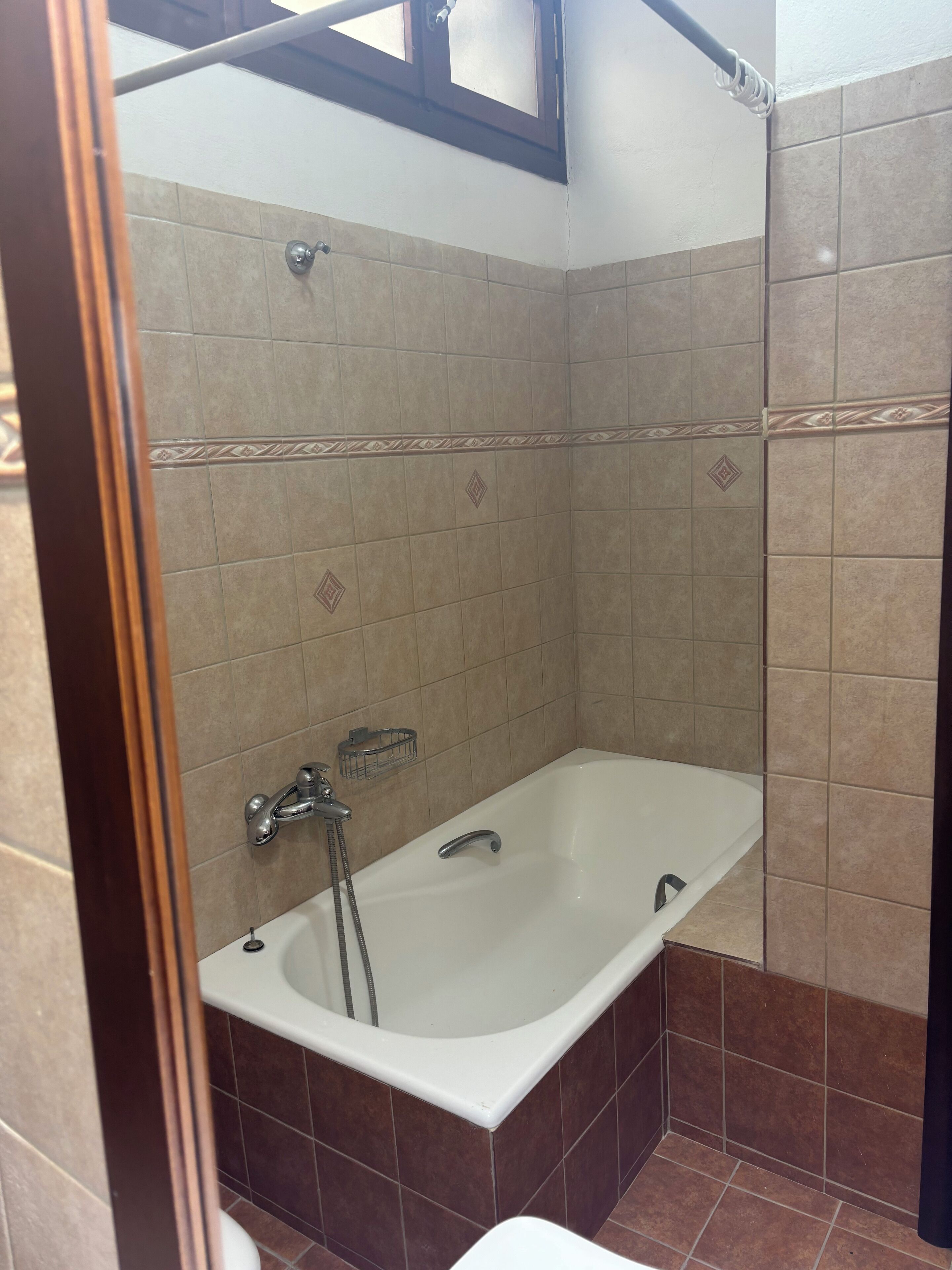 Une salle de bain avec une baignoire, une douche et un porte-serviettes.