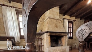 A traditional room with a stone fireplace, wooden furniture, and a large bed. - Melina Stone Villa (Roumelí)