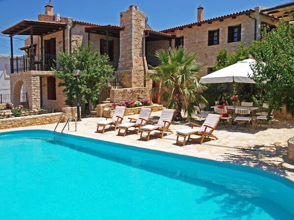 Una piscina al aire libre de temporada, sombrillas