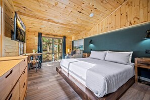 Une pièce aux murs lambrissés, contenant un lit, un bureau et une chaise.