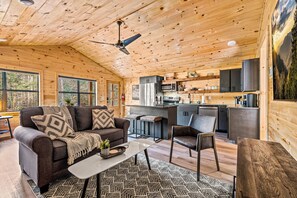 Un intérieur de chalet chaleureux comprenant un espace de vie, une cuisine et un coin repas.