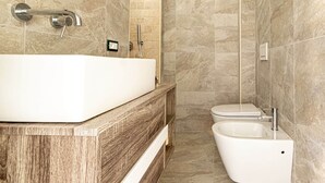 A modern bathroom with a large bathtub, a separate toilet, and a bidet. - Il Gelso - Sea View Holiday Home in Pomonte - Elba Island (Pomonte)