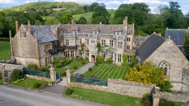 A large, historic stone building with multiple windows and a well-maintained lawn. - Spacious Country Farmhouse in Rewilding Landscape (Mapperton)
