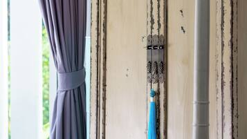 Une porte dotée d’un loquet métallique et d’une frange bleue qui y est suspendue.