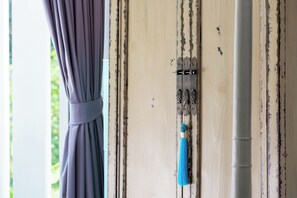 Eine Tür mit einem Metallriegel und einem blauen Quastenbespiel.