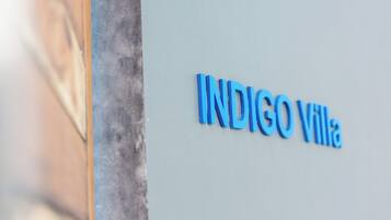 Le nom «
INDIGO Villa
» est inscrit sur un mur de couleur claire.