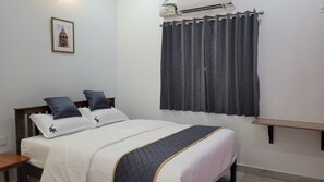 Relax in a serene space with a comfortable bed, air conditioning, and a stylish bench.