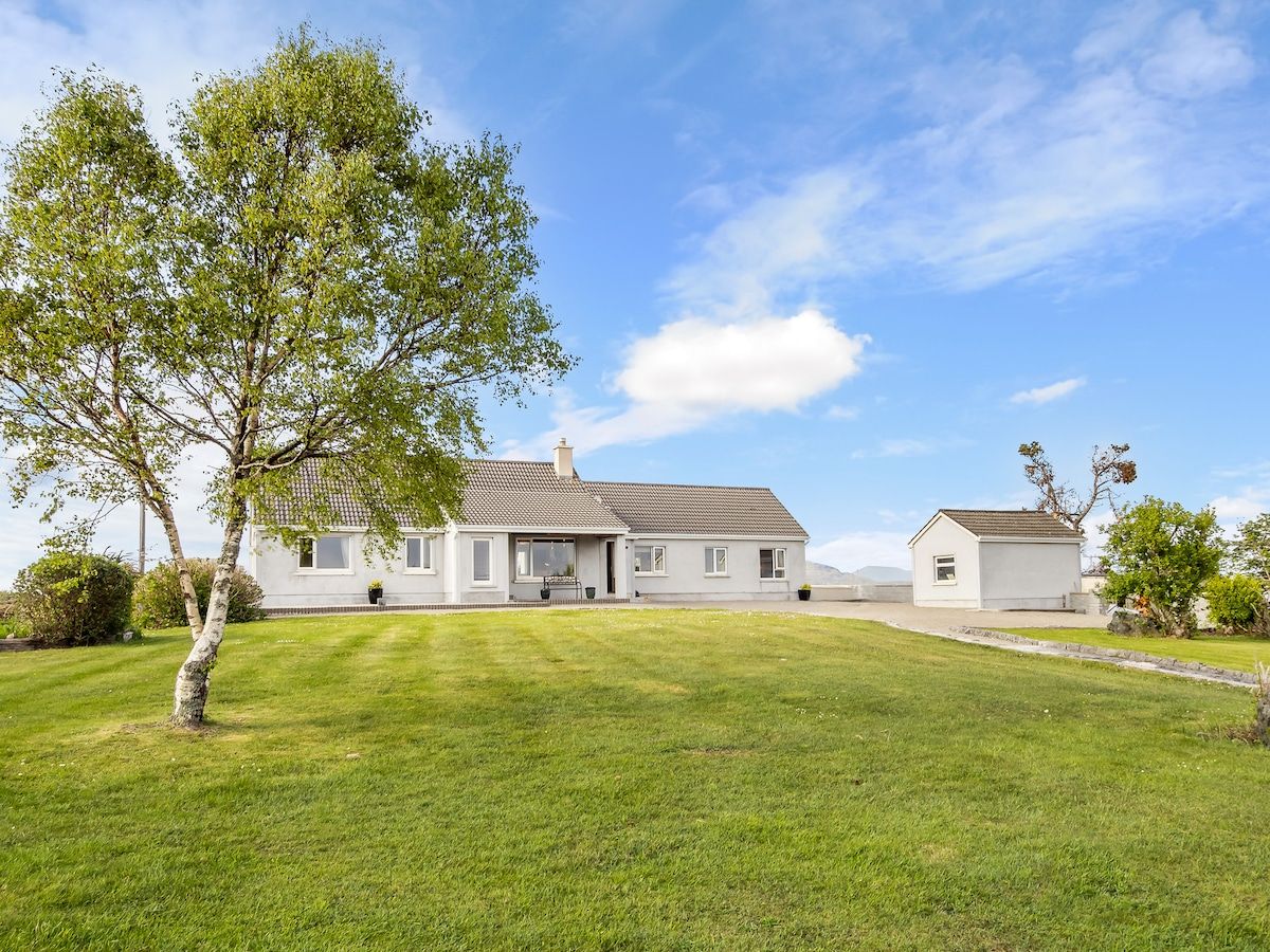 A two-story house with a front lawn and a small detached garage.