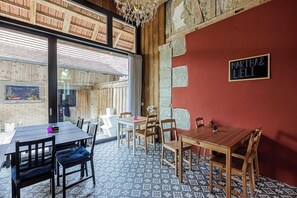 A dining area with wooden tables and chairs, a red accent wall, and a chalkboard sign reading "Martha & Ueli". - Uelis-Stoeckli (Meikirch)