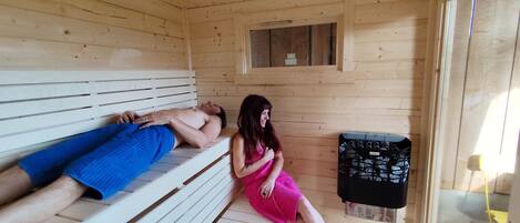 Una sauna de madera con bancos, una ventana pequeña y un panel de control.