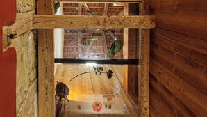 Un intérieur en bois avec une fenêtre en verre, des poutres en bois et un mur en briques.
