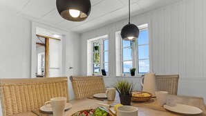 A dining area with wicker furniture, white plates, and a fruit basket. - "Ilze" - 20m from the sea by Interhome (Bandholm)