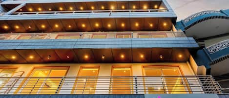 A multi-story hotel with balconies and a neon sign reading "goSTOPS".