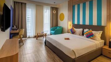 Una habitación de hotel con una cama, un escritorio, una silla y un televisor.