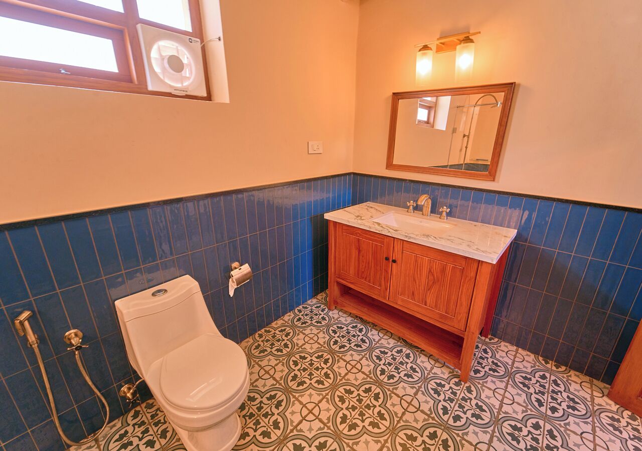 Et badeværelse med toilet, vask og bruser.