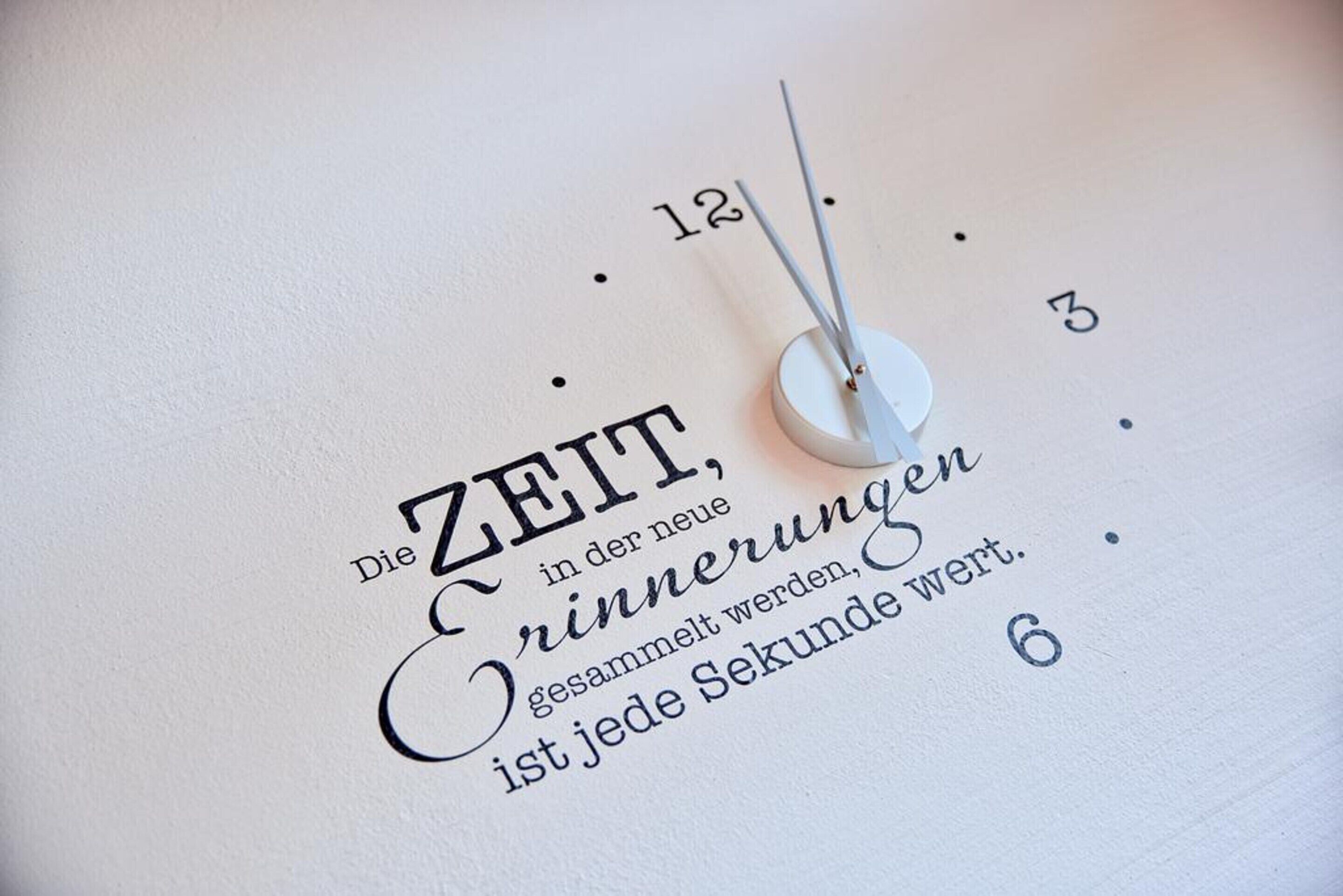 A clock with a minimalist design and German text on the face.