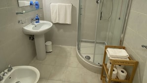 Ein Badezimmer mit Duschkabine, Waschbecken, Bidet und Toilette.