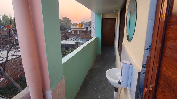 A narrow corridor with a view of the sunset, a sink, and a mirror. - Sneh Homestay (Faizabad)