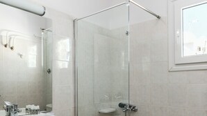 Une salle de bain moderne avec une douche à parois de verre, un meuble-lavabo en bois et un grand miroir.