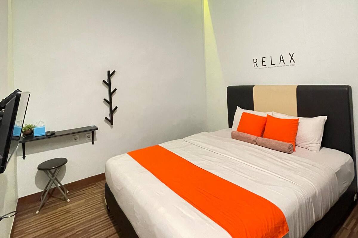 A modern bedroom with a bed, a desk, and a chair.