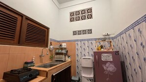 Una cocina compacta con estufa a gas, lavamanos y dispensador de agua.