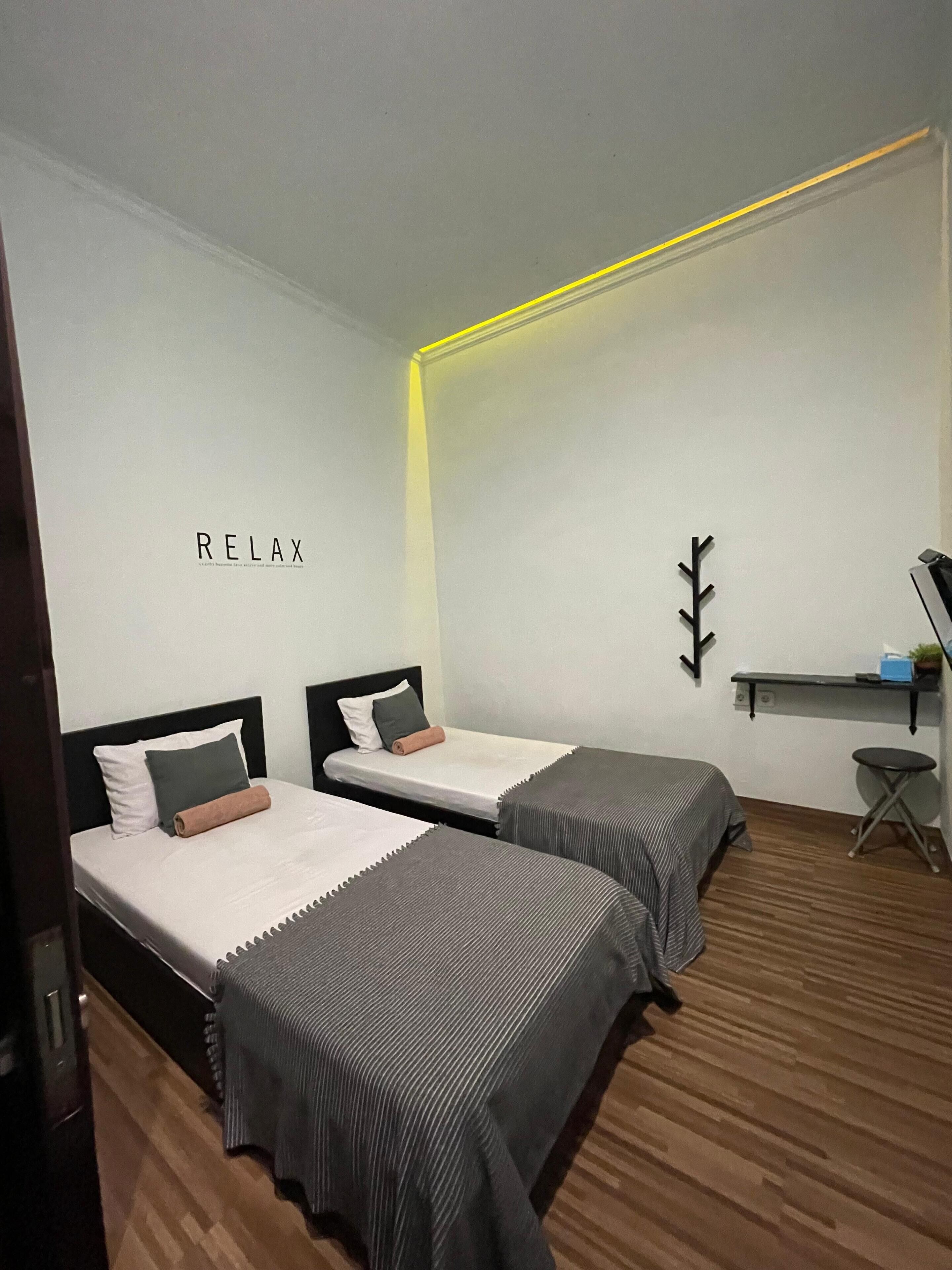 Ein Zimmer mit zwei Betten, einem Schreibtisch und einem Stuhl.
