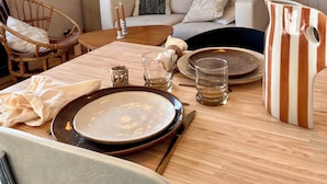 Een eethoek met een houten tafel voor twee personen, een bank en een radiator.