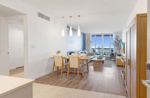 Un espace de vie moderne comprenant un coin repas, un canapé, une table basse et une vue sur la ville.