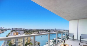 A high-rise building with a view of a marina and cityscape.