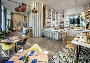 A modern restaurant with a bar area, wooden tables, and chairs. - Serenity by the Sea |  Balcony Views + Resort Pool (Hollywood)