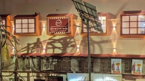Un edificio de varios pisos con elementos arquitectónicos asiáticos tradicionales, como ventanas decorativas y un letrero de restaurante.