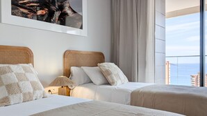 A hotel room with two beds, a large window with a view of the sea, and a framed artwork on the wall. - BENIDORM BEACH magic apartment (Benidorm)