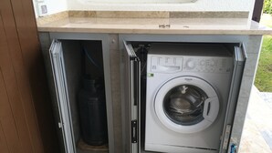 A compact, built-in washer and dryer unit with a control panel, located under a countertop. - Cometa 3 in Bibione With 2 Bedrooms and 2 Bathrooms (San Michele al Tagliamento)