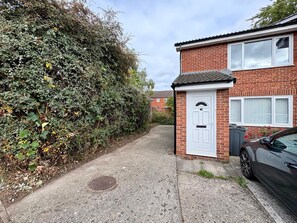 A residential street with a brick house, a white door, and a parked car. - Comfortable 1 Bed Darlington Apartment w Parking (Darlington)