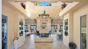 A spacious lobby with a central fireplace, seating area, and a sign indicating no food or drink permitted.