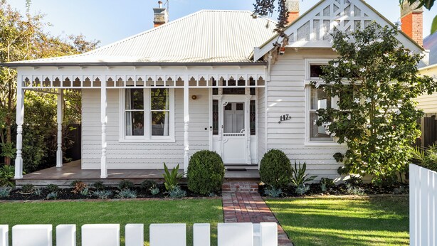 A white two-story house with a covered porch, a brick pathway, and a well-maintained garden. - Brighton Pool Paradise: Designer 3BR Retreat Near Beach & Café Culture (Brighton)