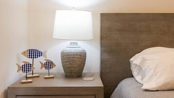 Une table de chevet avec une lampe, des poissons décoratifs et un vase à motifs.