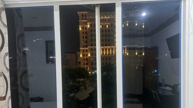 A room with a large window, a flat-screen TV, and a visible balcony area. - Hotel Selver Shinn & Restaurant (Phnom Penh)