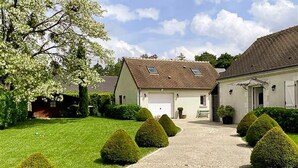 Une maison à deux étages avec une allée en gravier menant à un garage.
