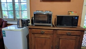 A kitchen with a white Hisense refrigerator, a microwave, and a Samsung microwave on a wooden cabinet. - Historic Tyford House, close to all amenities (Dongara)