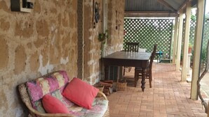 An outdoor covered patio with wicker furniture, a table, and chairs. - Historic Tyford House, close to all amenities (Dongara)