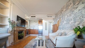 Uma sala de estar moderna com lareira, TV de tela plana, sofá e área de refeições.