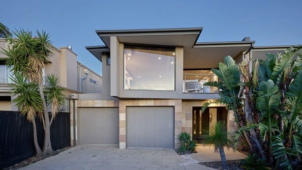A modern two-story house with a large balcony, a garage, and tropical plants. - Melbourne Beachfront Family Home with panoramic view (Black Rock)