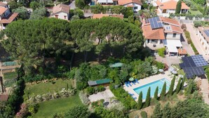 An aerial view of a residential area with a swimming pool surrounded by trees and solar panels on the roofs. - Beautiful  villa with A/C, private pool, WIFI, TV, terrace, pets allowed and panoramic view (Montelupo Fiorentino)