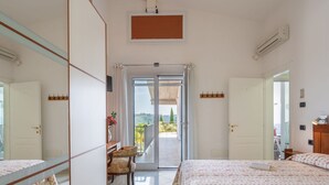 A hotel room with two beds, a desk, a chair, and a balcony with a view. - Beautiful  villa with A/C, private pool, WIFI, TV, terrace, pets allowed and panoramic view (Montelupo Fiorentino)