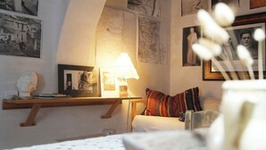 Un dormitorio con una cama, una lámpara, un mapa y un busto en una estantería.