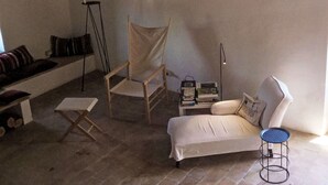 A cozy room with a sofa, a chair, a small table, and a bookshelf.