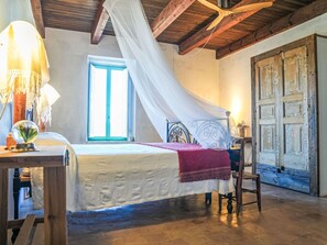 Ein Schlafzimmer mit Bett, Fenster, Tür und Lampe.