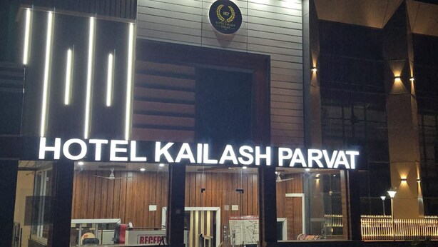 The exterior of Hotel Kailash Parvat with a reception desk and a sign indicating the distance to the nearest bus stop. - Hotel kailash parvat (Amb)