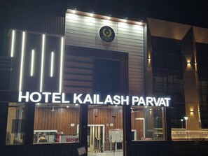 Esterno dell'Hotel Kailash Parvat, con la reception e un cartello che indica la distanza dalla fermata dell'autobus più vicina.